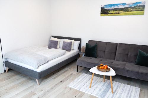 uma sala de estar com um sofá e uma cama em Entdecke das idyllische Allgäu - Verbringe deinen Traumurlaub in unserer gemütlichen Ferienwohnung em Immenstadt im Allgäu