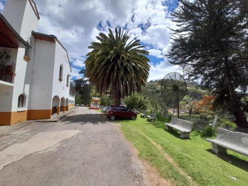 a car parked next to a building with a palm tree at Hotel Casa de Peregrinos in Ipiales