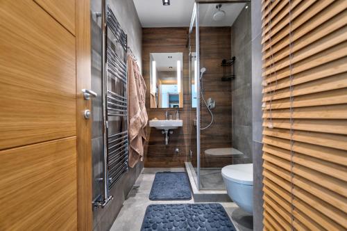 a bathroom with a shower and a toilet and a sink at Apartman Thalia Kalman in Zlatibor