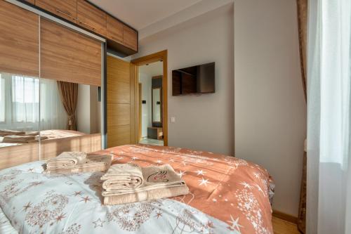 a bedroom with a bed with towels on it at Apartman Thalia Kalman in Zlatibor