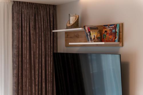 a living room with a tv and a curtain at Apartman Thalia Kalman in Zlatibor