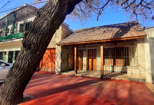 un edificio con una puerta junto a un árbol en APART CENTRO RIOJA, Zona Residencial, Parking privado gratis a 100 mts en Mendoza