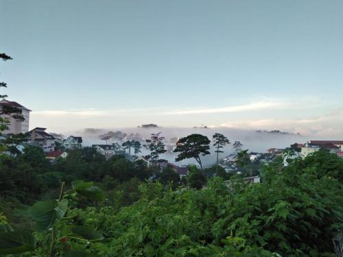 una vista de una ciudad con nubes en el cielo en Nhà của Sóc, en Da Lat