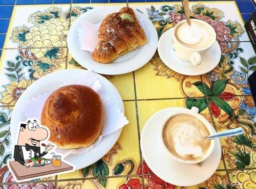 a table with plates of pastries and a cup of coffee at Guest Roma House in Rome