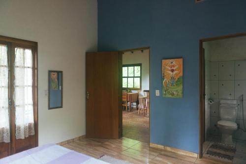a room with a toilet and a blue wall at Ytororô O som das águas in Paraty