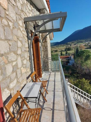 balkon z krzesłami i stołem w budynku w obiekcie Xenios Petritis w mieście Liwadia