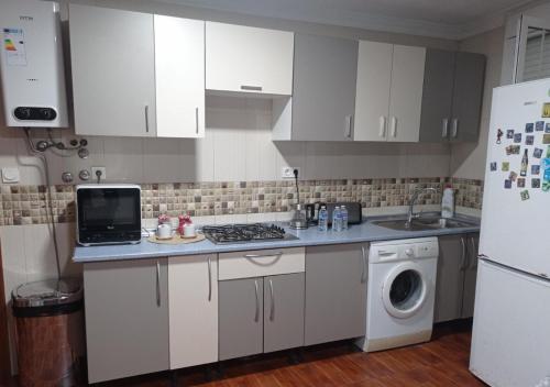 a kitchen with white cabinets and a washer and dryer at La viña in Melilla