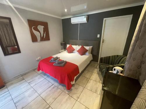 a bedroom with a bed with a red blanket at Marion Lodge in Johannesburg