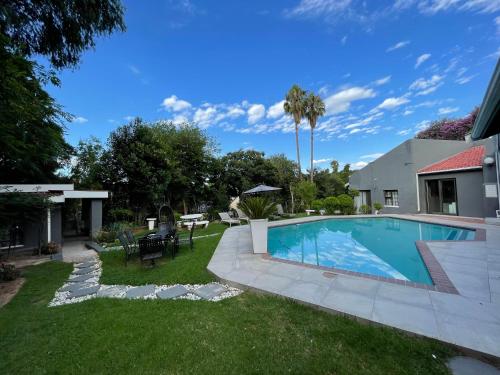 podwórko z basenem i domem w obiekcie Marion Lodge w mieście Johannesburg