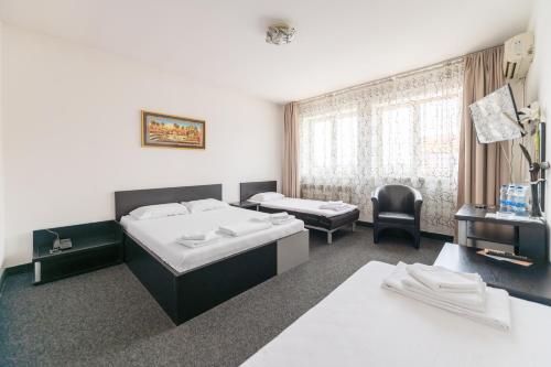 a hotel room with two beds and a chair at Hotel Villa Sarto in Belgrade
