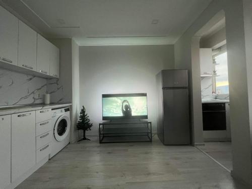 a kitchen with a refrigerator and a tv on the wall at Amazing view central 1 bedroom apartment in Pazardzhik