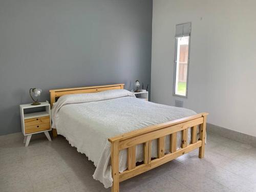 a bedroom with a wooden bed and a window at Amplio Dpto en el corazón de Carhué in Carhué