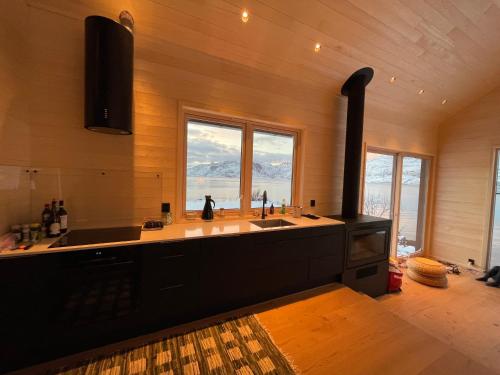 a kitchen with a sink and a stove at Superior Cabin with Private Beach Lofoten 