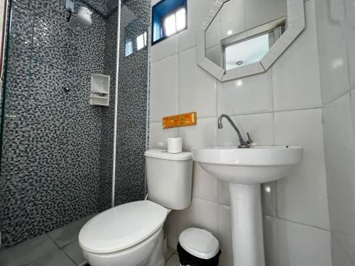 ein weißes Bad mit einem WC und einem Waschbecken in der Unterkunft Casa dos franceses guesthouse ilha grande in Abraão