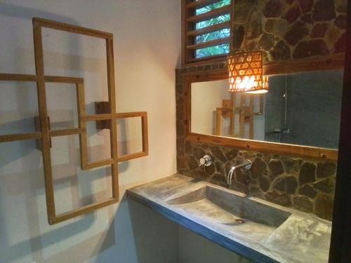 a bathroom with a sink and a mirror at Villa Colibri in Nosy Be