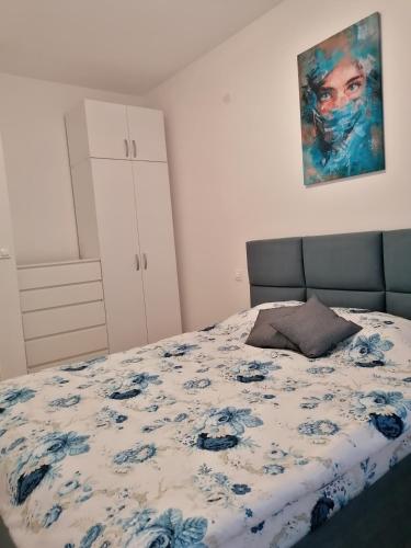 ein Schlafzimmer mit einem Bett mit einer blauen und weißen Decke in der Unterkunft Tanja's Apartment in Štip