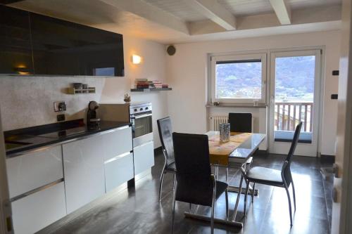 een keuken met een tafel en stoelen in een kamer bij Grazioso appartamento Aosta in Aosta