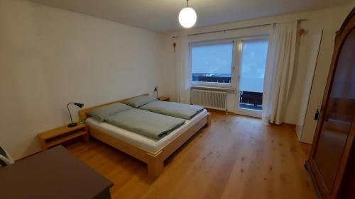 a bedroom with a bed and a large window at Apartment Kirchmair in Innsbruck