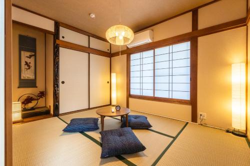 a room with a table and some blue mats at Tsukiyume Kan - House with Parking, 10Mins to USJ, Tennoji, Namba in Osaka