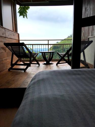 a room with a bed and a balcony with a view at Ella HIDE VIEW in Ella