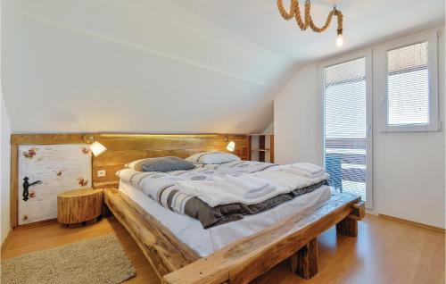 a bedroom with a large bed with a wooden headboard at Amazing Home In Varazdinske Toplice With 3 Bedrooms, Outdoor Swimming Pool And Sauna in Varaždinske Toplice