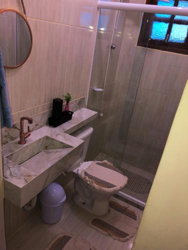 uma casa de banho com um chuveiro, um lavatório e um WC. em Casa de praia em Figueira, Arraial do Cabo - Casa Caribe em Arraial do Cabo