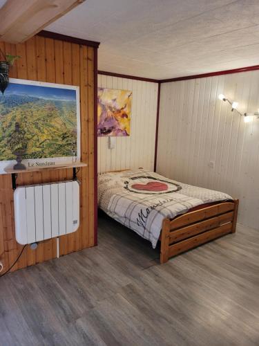 1 dormitorio con 1 cama y una pintura en la pared en Le Nid Du Caveau, en Ferrette