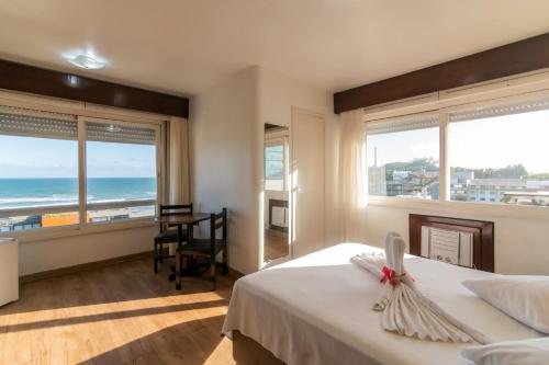 a bedroom with a bed with a view of the ocean at Farol Hotel in Torres