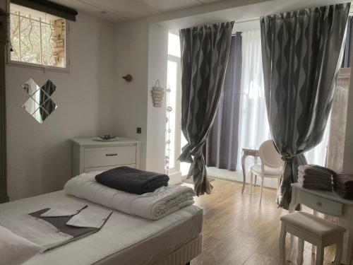 biała sypialnia z łóżkiem i oknem w obiekcie Gîte Comme à la maison w Hyères
