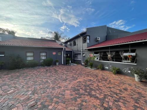 a brick driveway in front of a building at Marion Lodge in Johannesburg