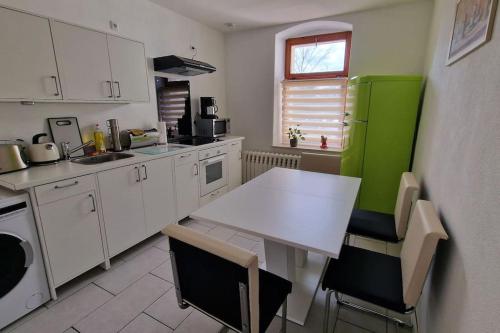 uma cozinha com uma mesa branca e um frigorífico verde em Großzügige Fewo Peter in Bärenstein em Bärenstein