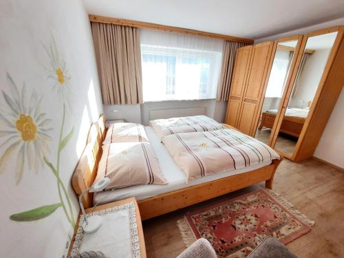 ein kleines Schlafzimmer mit einem Bett und einem Spiegel in der Unterkunft Apartment Schilcher in Oberau