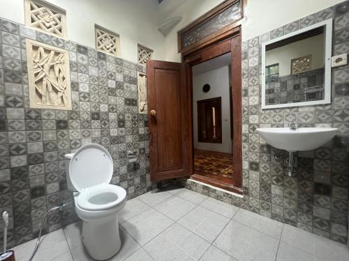 a bathroom with a toilet and a sink at Dream Village in Jarakan