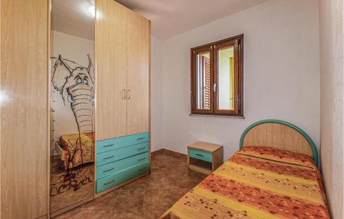 a bedroom with a bed and a painting on the wall at 2 Bedroom Beautiful Apartment In Castelsardo in Castelsardo