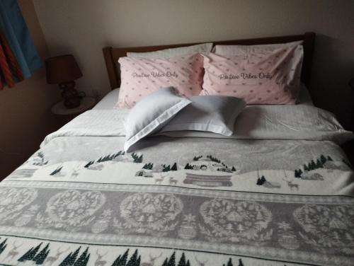 Una cama con una manta y almohadas encima en Eden Visoko, en Visoko