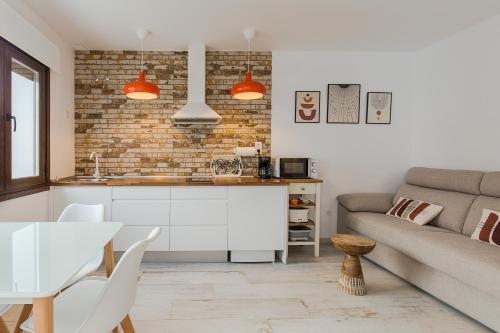 a kitchen and living room with a couch and a table at Apartamentos Rurales Cielo de Monfragüe in Malpartida de Plasencia