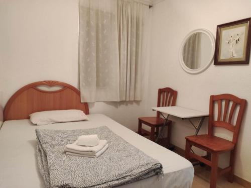 una camera da letto con un letto con due sedie e un tavolo di 30-3- Бюджетная КОМНАТА в квартире для 2 человека, Alicante ad Alicante
