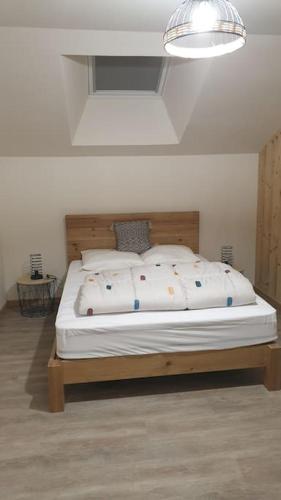 une chambre avec un grand lit avec une tête de lit en bois dans l'établissement La Chouette-Appartement, à Gérardmer