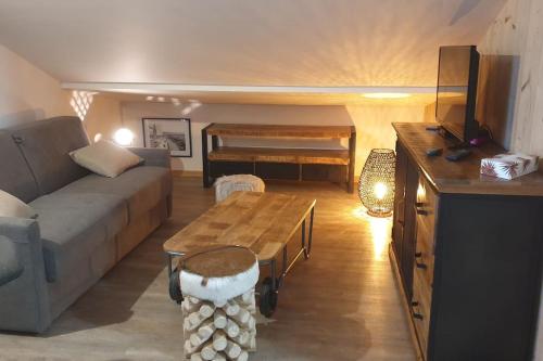 un salon avec un canapé et une table dans l'établissement La Chouette-Appartement, à Gérardmer