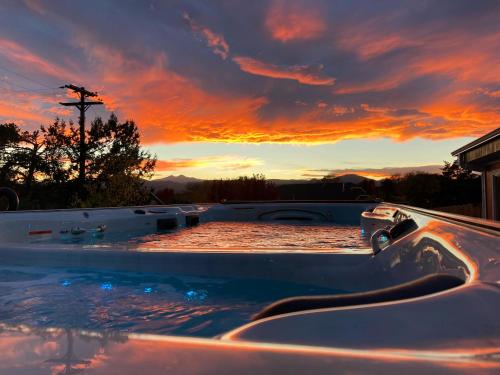 a hot tub with a sunset in the background at The Oasis on Eisenhower in Loveland