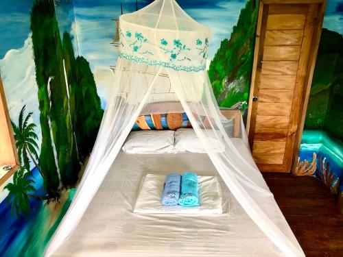 een slaapkamer met een bed in een kamer met een schilderij bij Green Hill Restaurant & Cottages in San Vicente