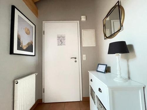 a hallway with a white door and a mirror at Das Bergquartier - Ferienwohnung Mühlberg in Oberau