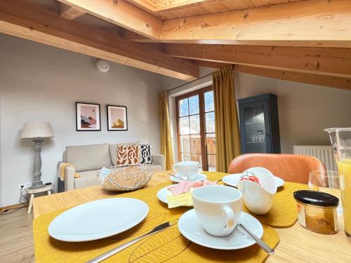 a dining room table with white dishes on it at Das Bergquartier - Ferienwohnung Krottenkopf in Oberau