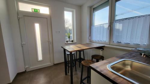 d'une cuisine avec deux tables, un évier et une fenêtre. dans l'établissement Relax Apartments Sárvár A2, à Sárvár