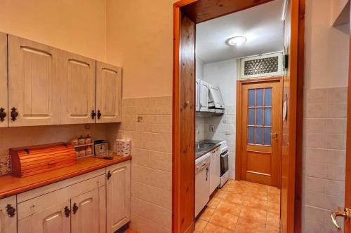 uma cozinha com armários de madeira e uma porta para um quarto em Biscione Large Apartment - Campo de Fiori by YourHost em Roma