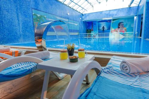 una camera con piscina, tavolo e sedie di GRAND ANİ HOTEL a Kars