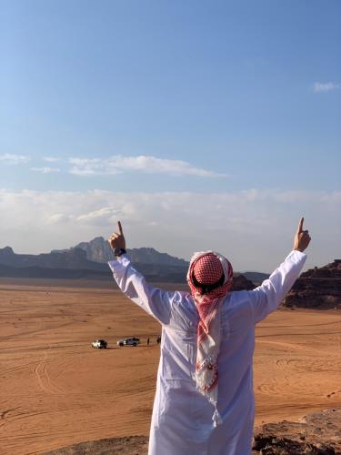 a woman standing in the desert with her arms outstretched at Rum desert magic in Wadi Rum