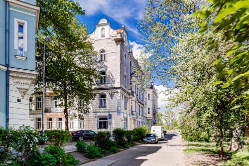 a large white building with a tower on a street at Kaizl Park Residence in Prague