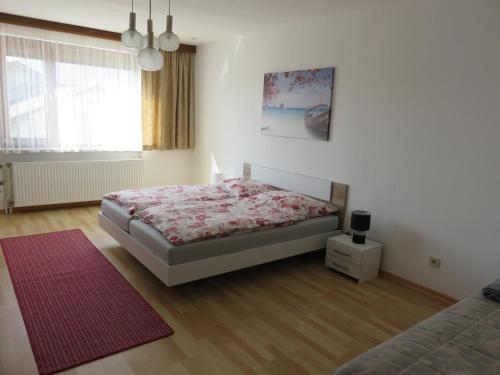 a bedroom with a bed and a red rug at Schöne Ferienwohnung in Kärnten Hunde gerne auf Anfrage in Sankt Veit an der Glan