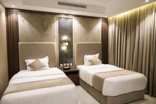 a bedroom with two beds and a mirror at جولدن نايت in Jeddah